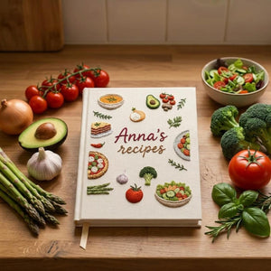 Hand embroidered recipe book featuring vegetables salads pizza lasagna soups herbs and family meal inspired food illustrations on linen cover