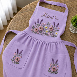 Personalized hand embroidered apron featuring lavender flowers, cottage garden blooms, botanical embroidery, and custom name on natural linen fabric.