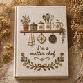 Hand embroidered recipe book featuring cottage kitchen shelf with teapot jars utensils and floral farmhouse embroidery on linen cover