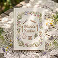 Personalized cottage kitchen hand embroidered recipe book featuring floral wreaths baking tools teapot bread cupcake and botanical embroidery
