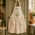 Personalized hand embroidered linen apron featuring daisy bouquet embroidery, custom name personalization, cottage garden floral design, and daisy pocket accents.