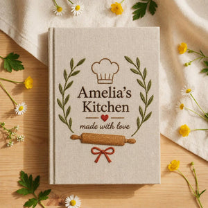 Personalized hand embroidered recipe book featuring chef hat rolling pin botanical wreath and custom kitchen text on linen cover