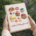 Personalized hand embroidered baking journal featuring cupcakes, donuts, fruit tarts, cakes, cookies and dessert themed illustrations on linen recipe book cover.
