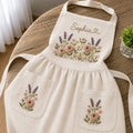 Personalized hand embroidered apron featuring lavender flowers, cottage garden blooms, botanical embroidery, and custom name on natural linen fabric.