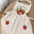 Personalized hand embroidered linen apron featuring strawberries, daisy flowers, botanical garden embroidery, and custom name personalization.
