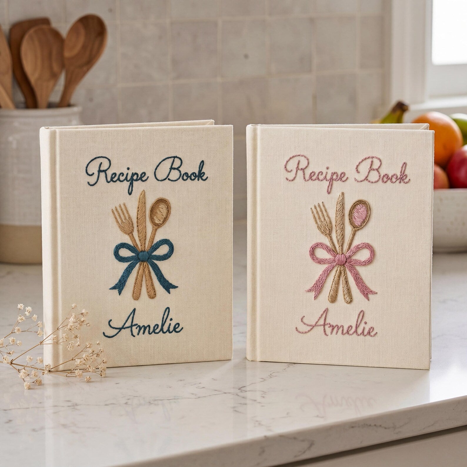 Personalized hand embroidered recipe book featuring fork, knife and spoon tied with a ribbon on a linen cover with custom name embroidery.