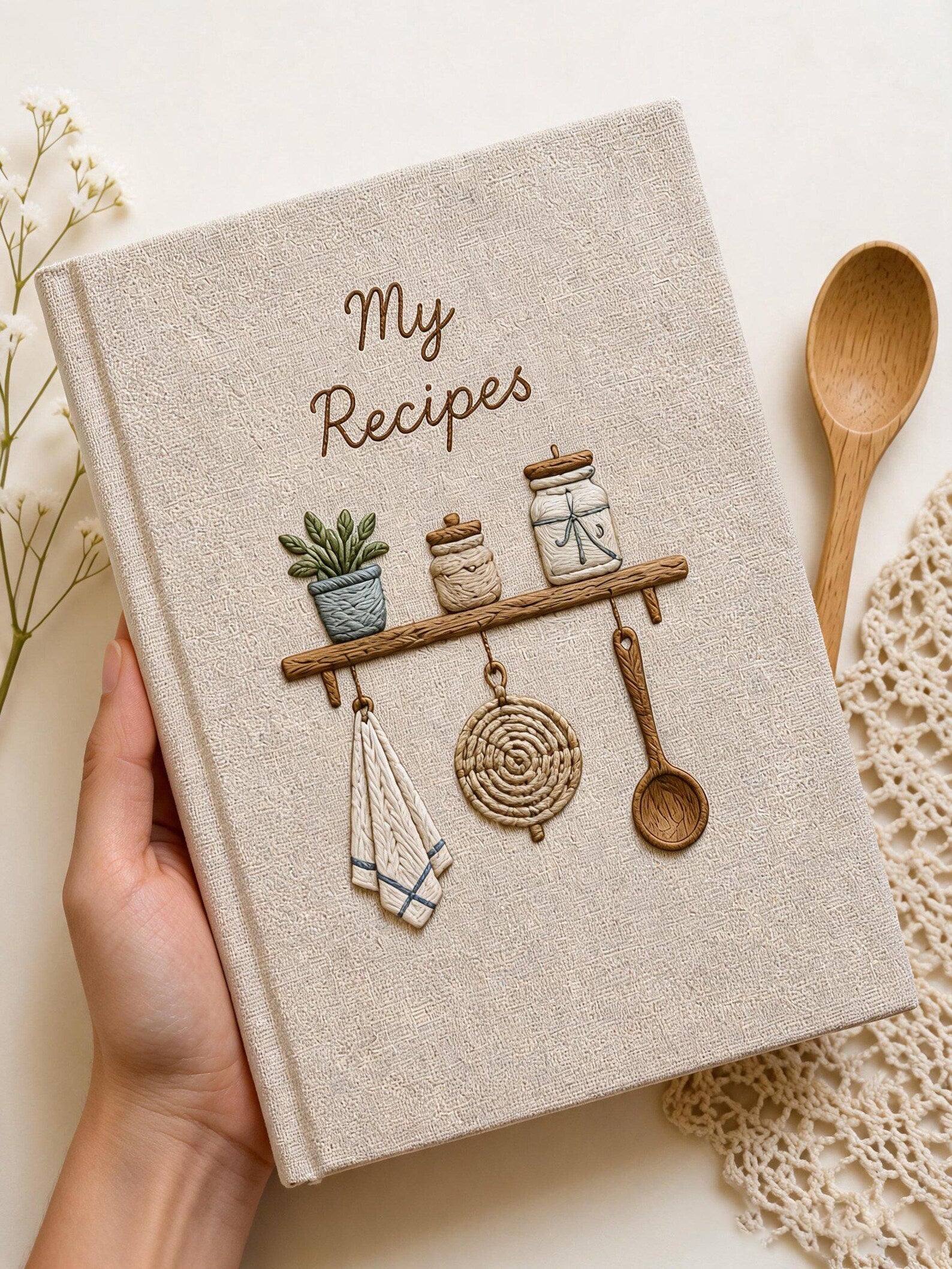 Hand embroidered recipe book featuring rustic pantry shelf with storage jars, botanical greenery, woven kitchen accents and cottage farmhouse decor.