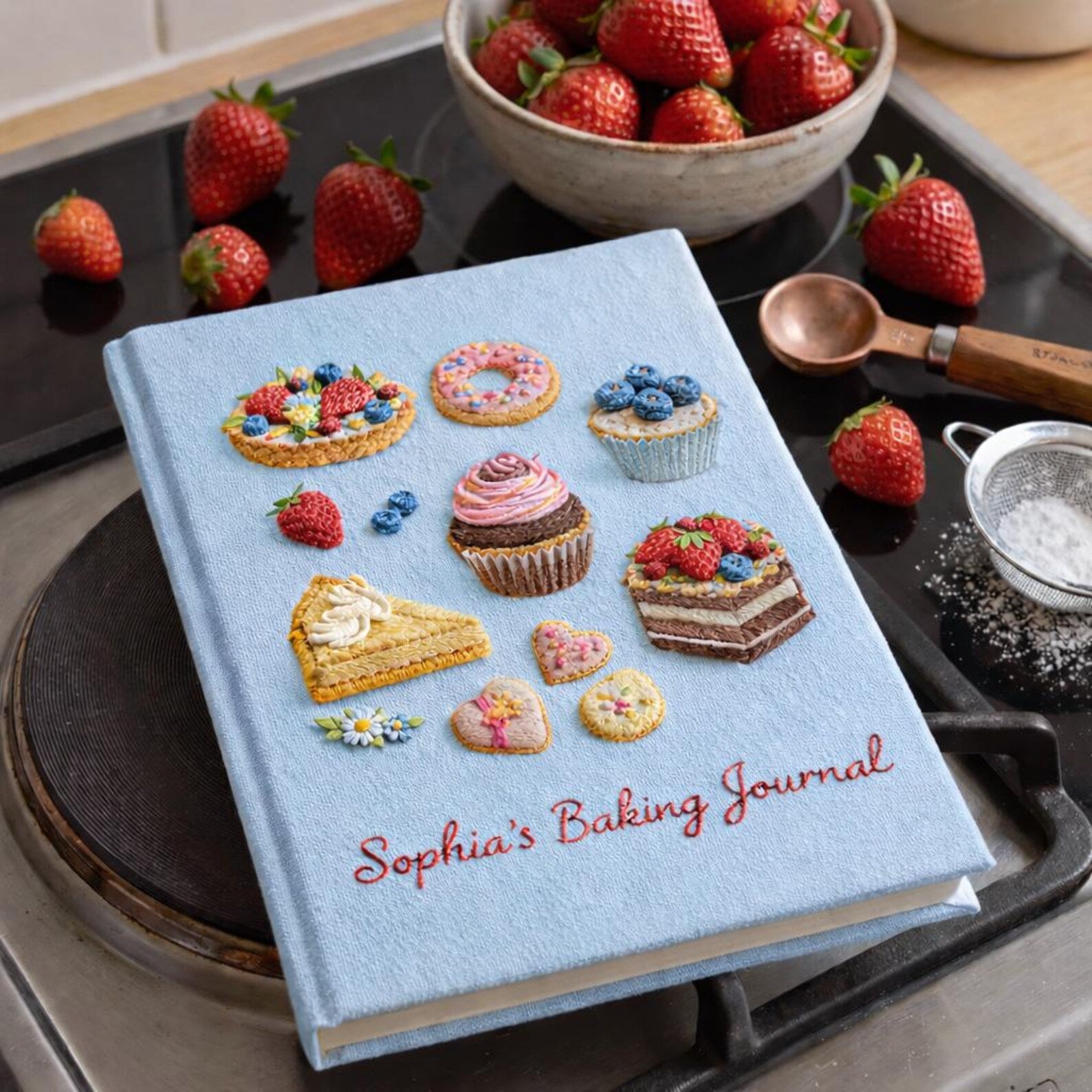 Personalized hand embroidered baking journal featuring cupcakes, donuts, fruit tarts, cakes, cookies and dessert themed illustrations on linen recipe book cover.