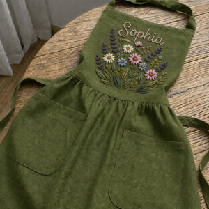 Personalized hand embroidered linen apron featuring wildflower bouquet embroidery, lavender flowers, daisies, and custom name embroidery.