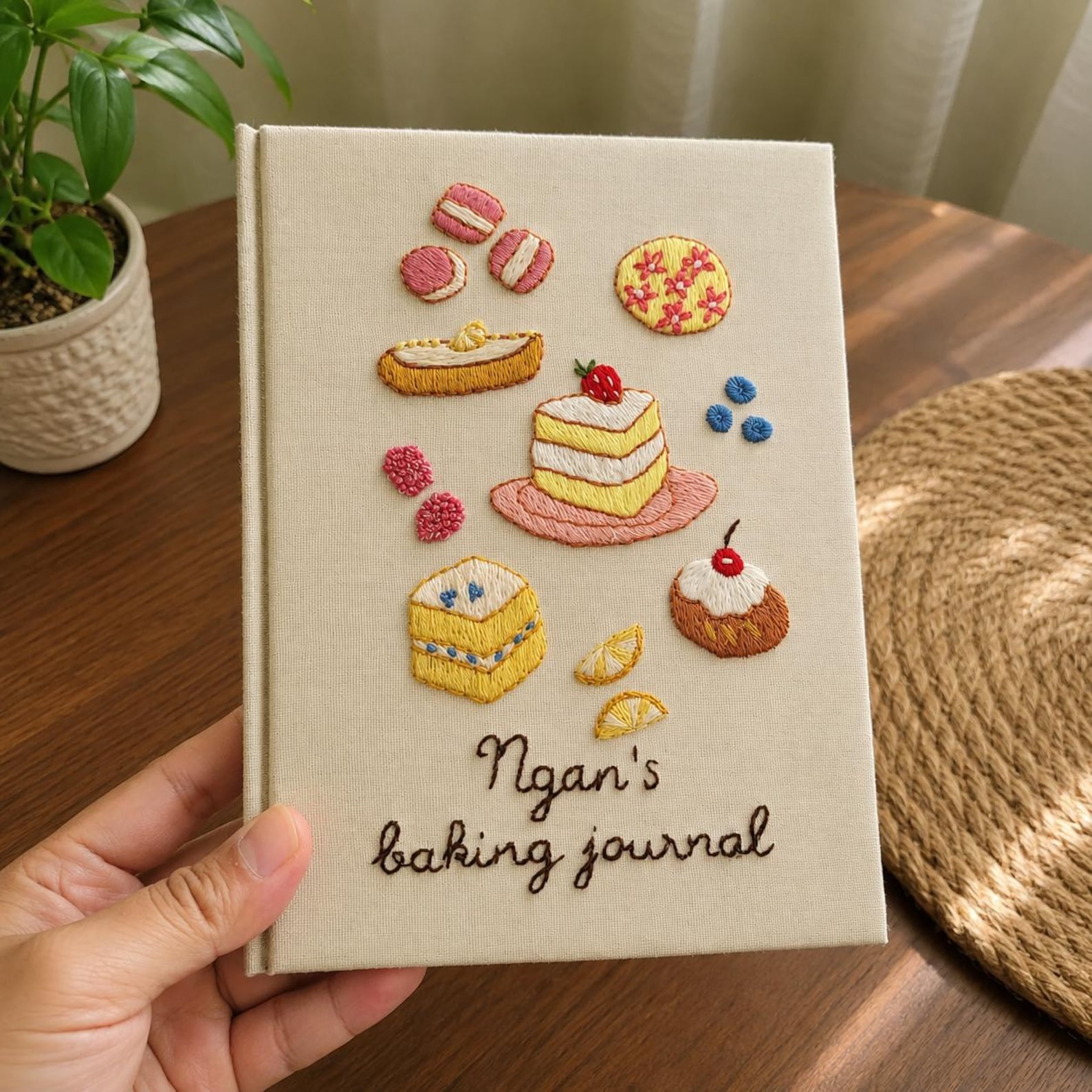 Hand embroidered baking journal featuring strawberry cake macarons pastries berries and dessert motifs on linen cover