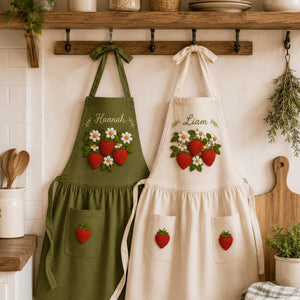 Personalized hand embroidered linen apron featuring strawberries, daisy flowers, botanical garden embroidery, and custom name personalization.
