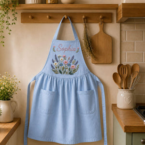 Personalized hand embroidered linen apron featuring wildflower bouquet embroidery, lavender flowers, daisies, and custom name embroidery.