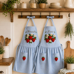 Personalized hand embroidered linen apron featuring strawberries, daisy flowers, botanical garden embroidery, and custom name personalization.